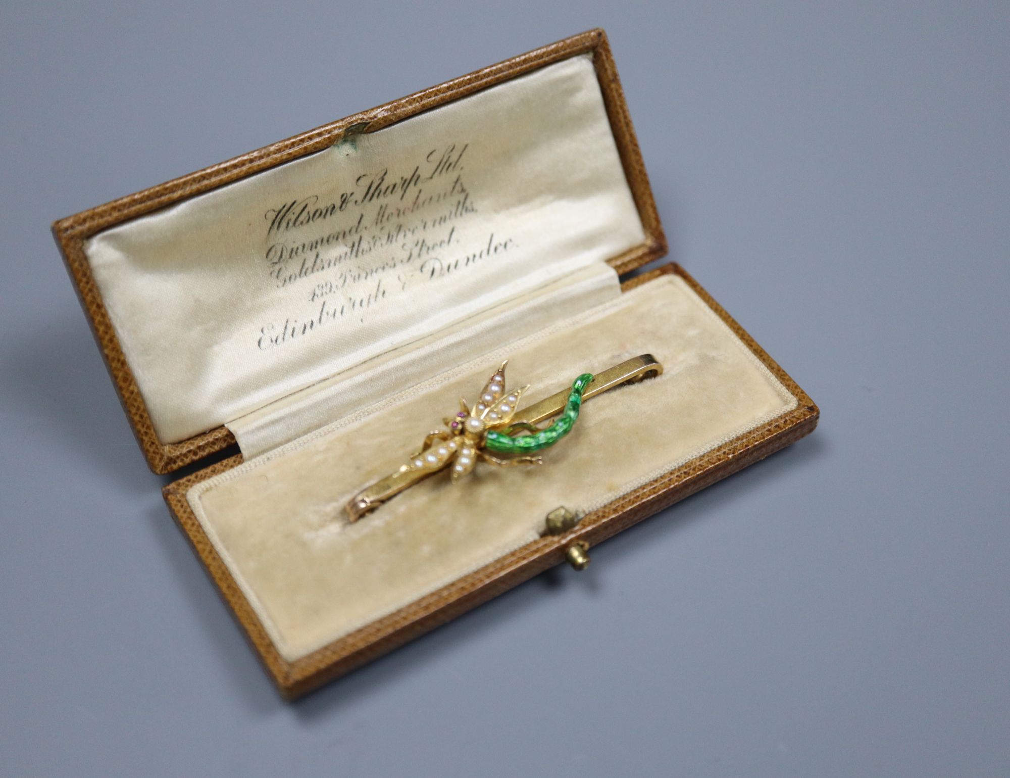 An Edwardian yellow metal, garnet?, seed pearl and green enamel set dragonfly bar brooch, 51mm, gross 6.7 grams.